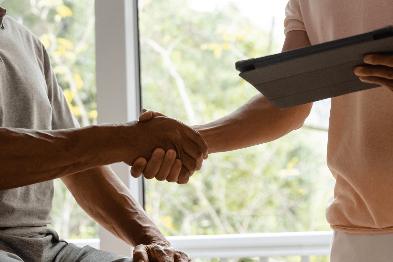 Handschlag zwischen Pflegefachkraft und Versichertem
